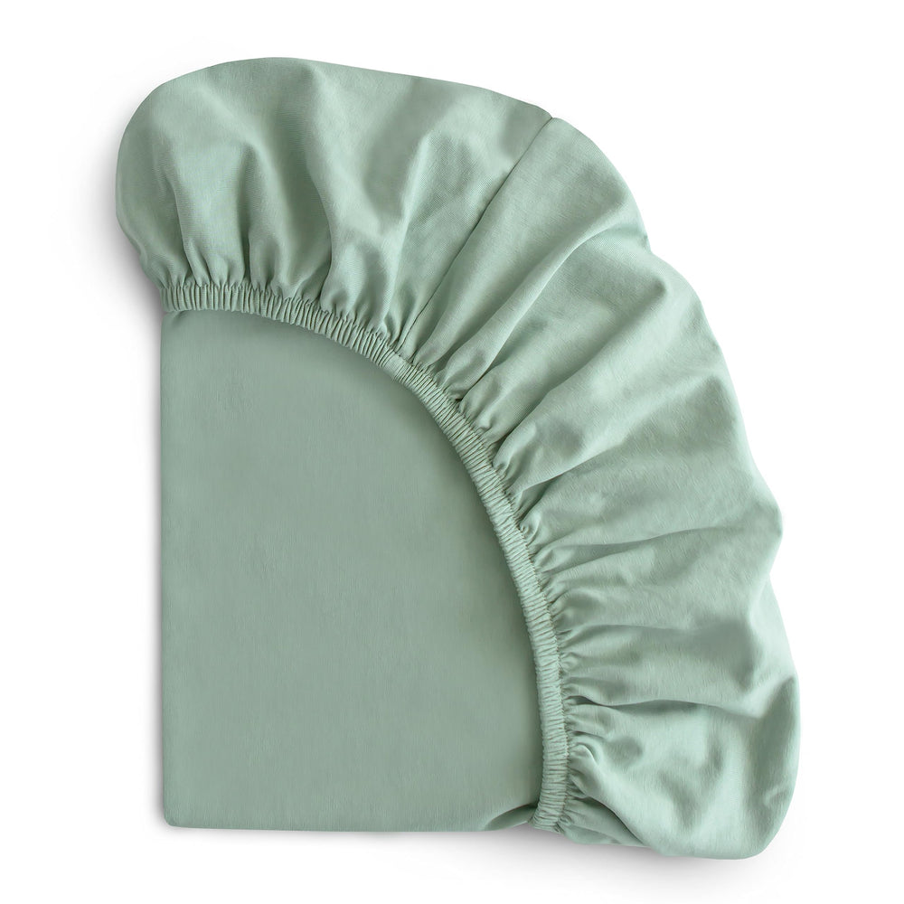 Mushie Stretchy Bassinet Sheet Roman Green on bassinet mattress for secure fit