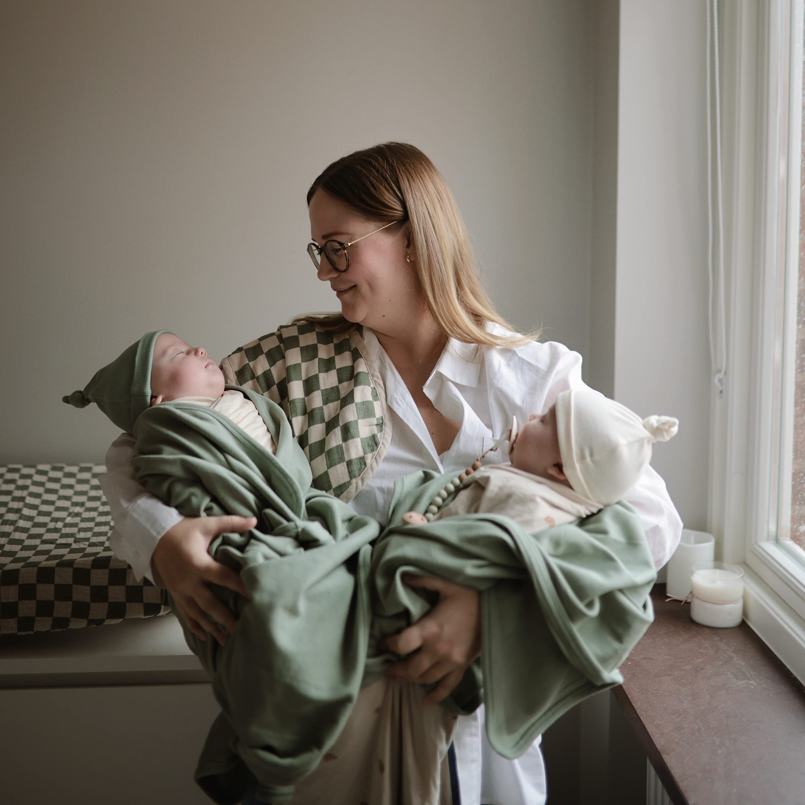 Mushie Stretchy Swaddle Blanket on crib demonstrates calm nighttime routine.