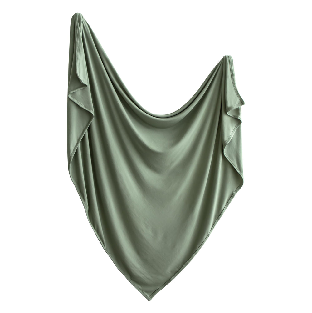 Mushie Stretchy Swaddle Blanket folded in dried-thyme provides soft, cozy warmth.