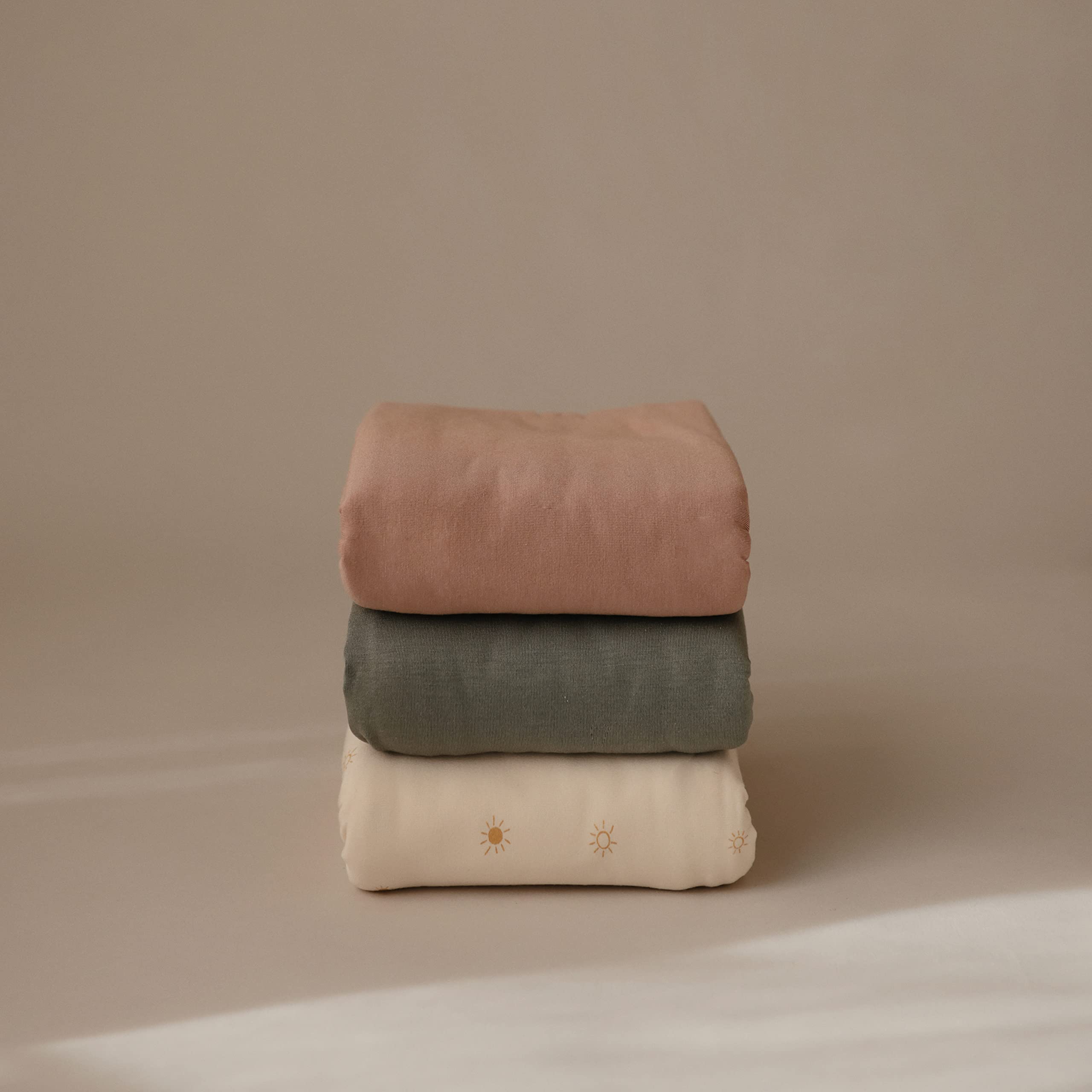 Mushie Stretchy Swaddle Blanket being used as blanket shows versatility.