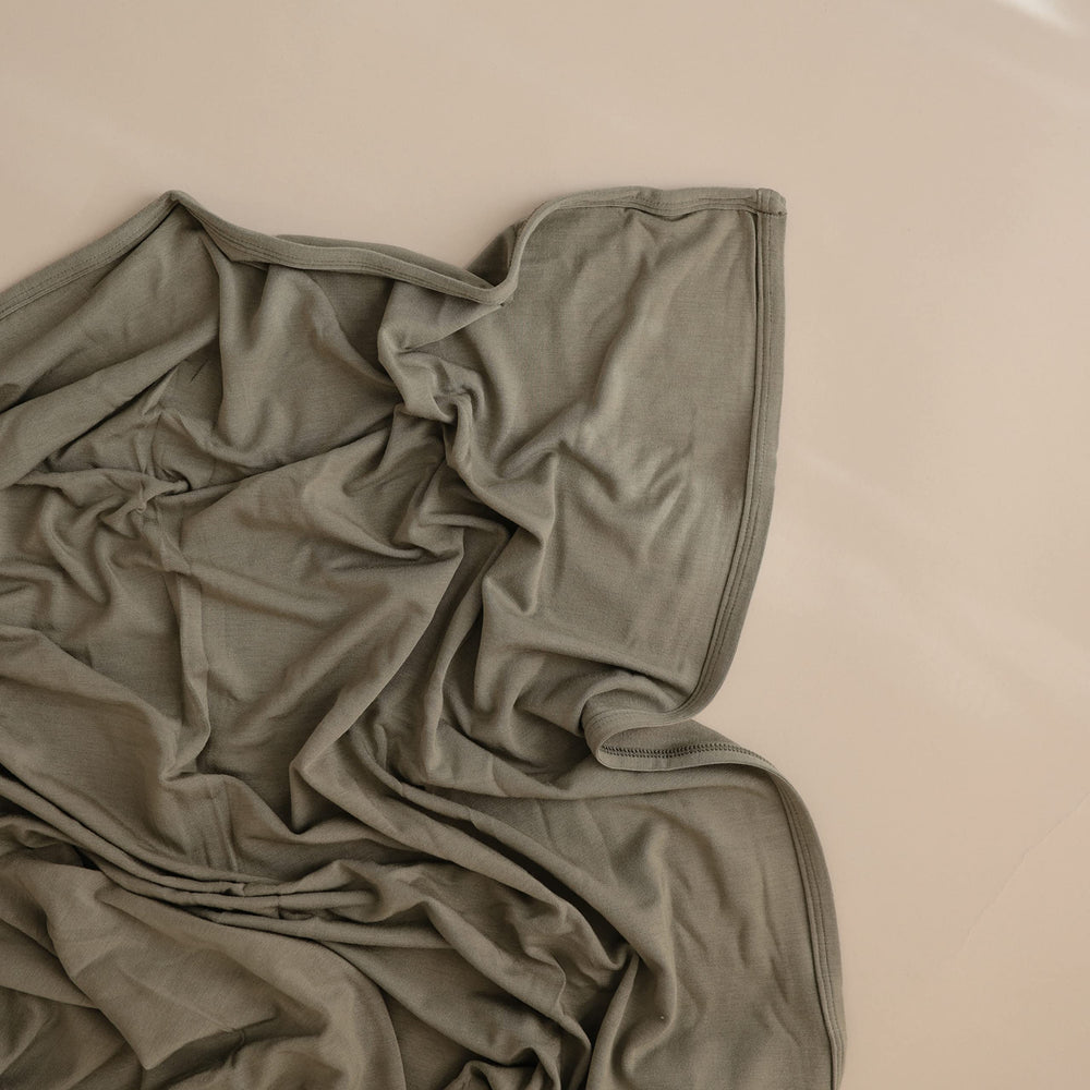 Mushie Stretchy Swaddle Blanket open showcases breathable modal-spandex fabric.