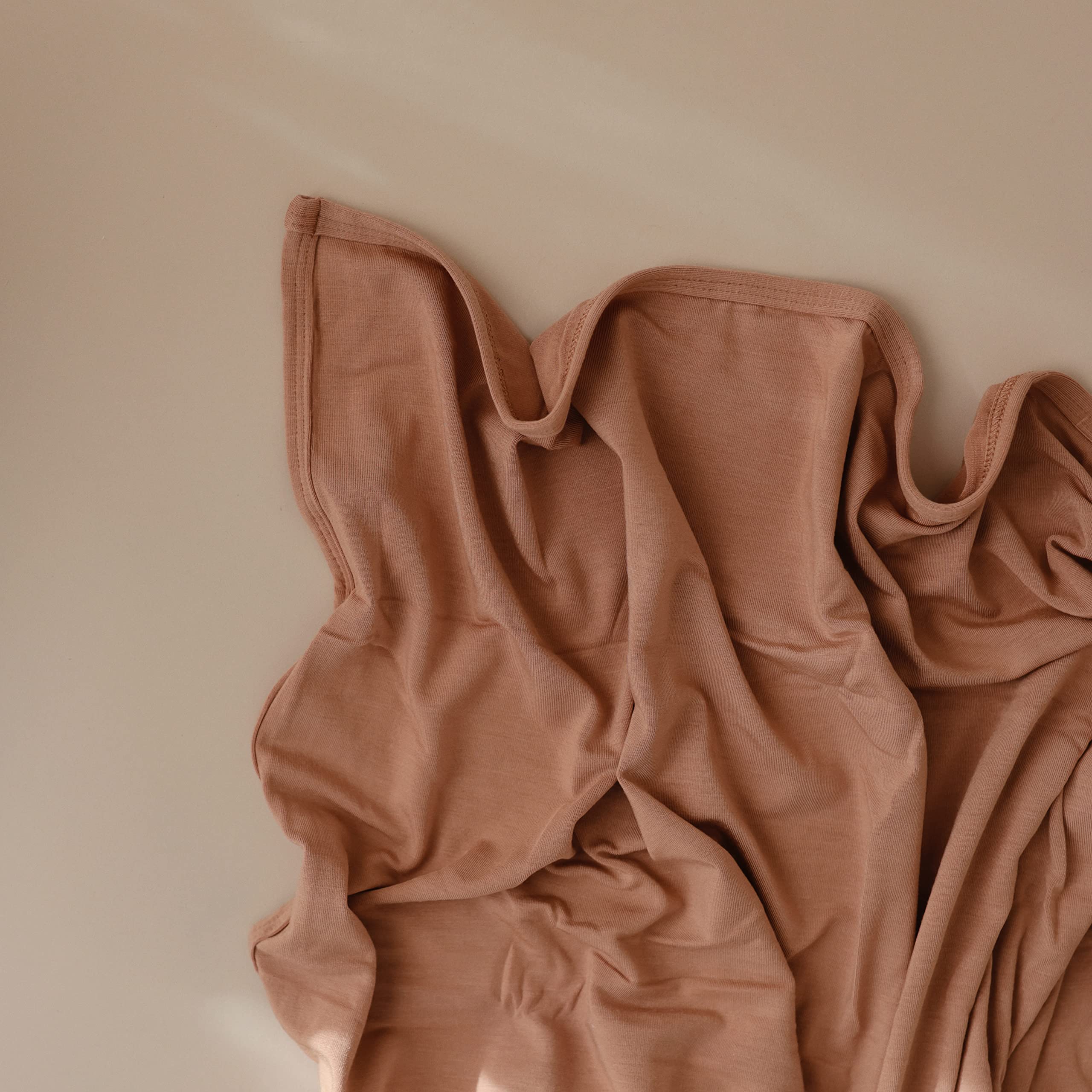 Mushie stretchy swaddle natural closeup fabric highlights soft modal finish.