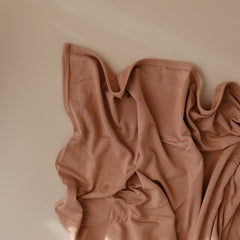 Mushie stretchy swaddle natural closeup fabric highlights soft modal finish.
