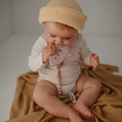 Mushie teether baby hand grip demonstrates easy hold during teething play.