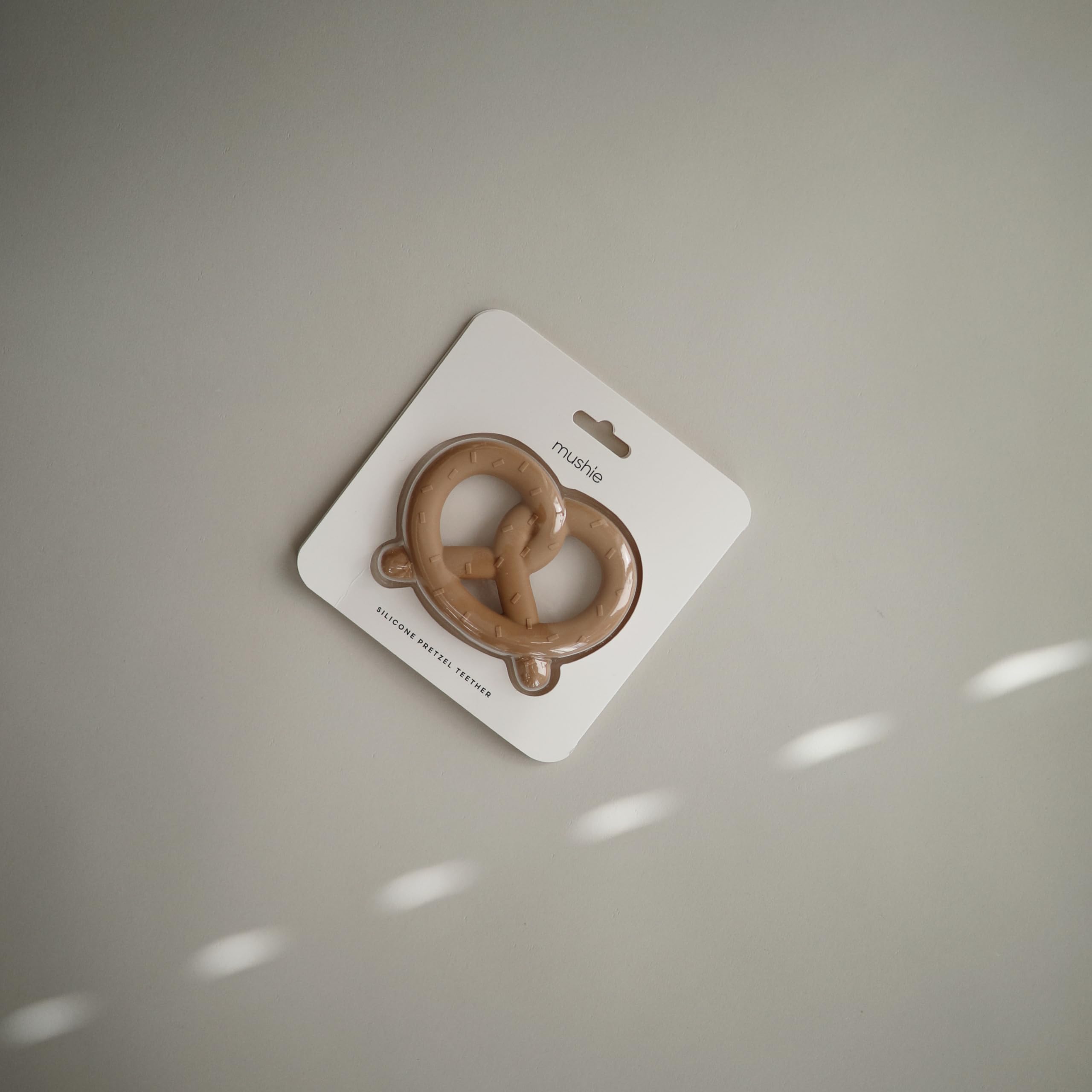 Mushie teether pretzel playtime setup encourages safe playful exploration.