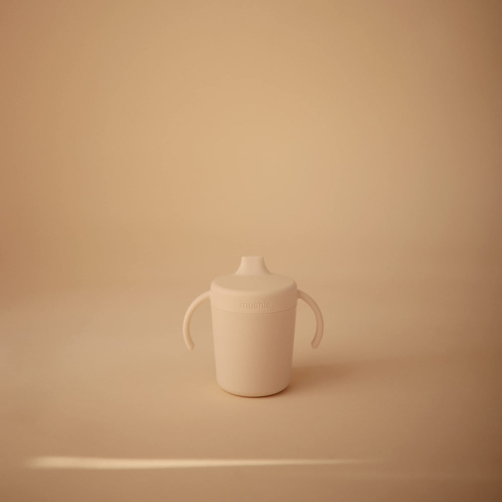 Mushie Trainer Sippy Cup Ivory handles grip for easy self-feeding.