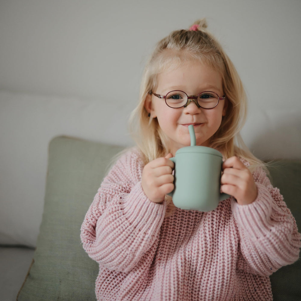 Mushie training cup displaying 6oz capacity for tiny hands and confident sipping.