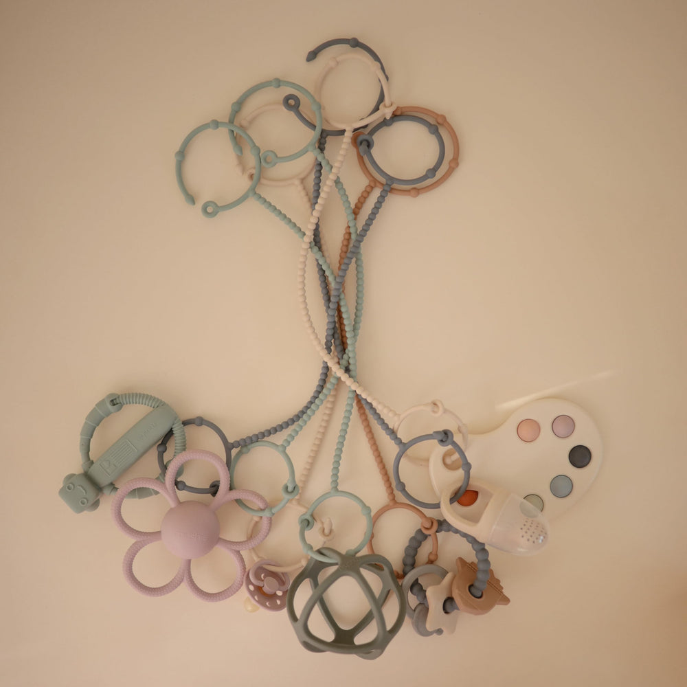 Mushie travel-ready straps shown with a sippy cup for mess-free outings.