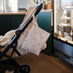 Mushie wet bags with snap-handle for easy stroller attachment.