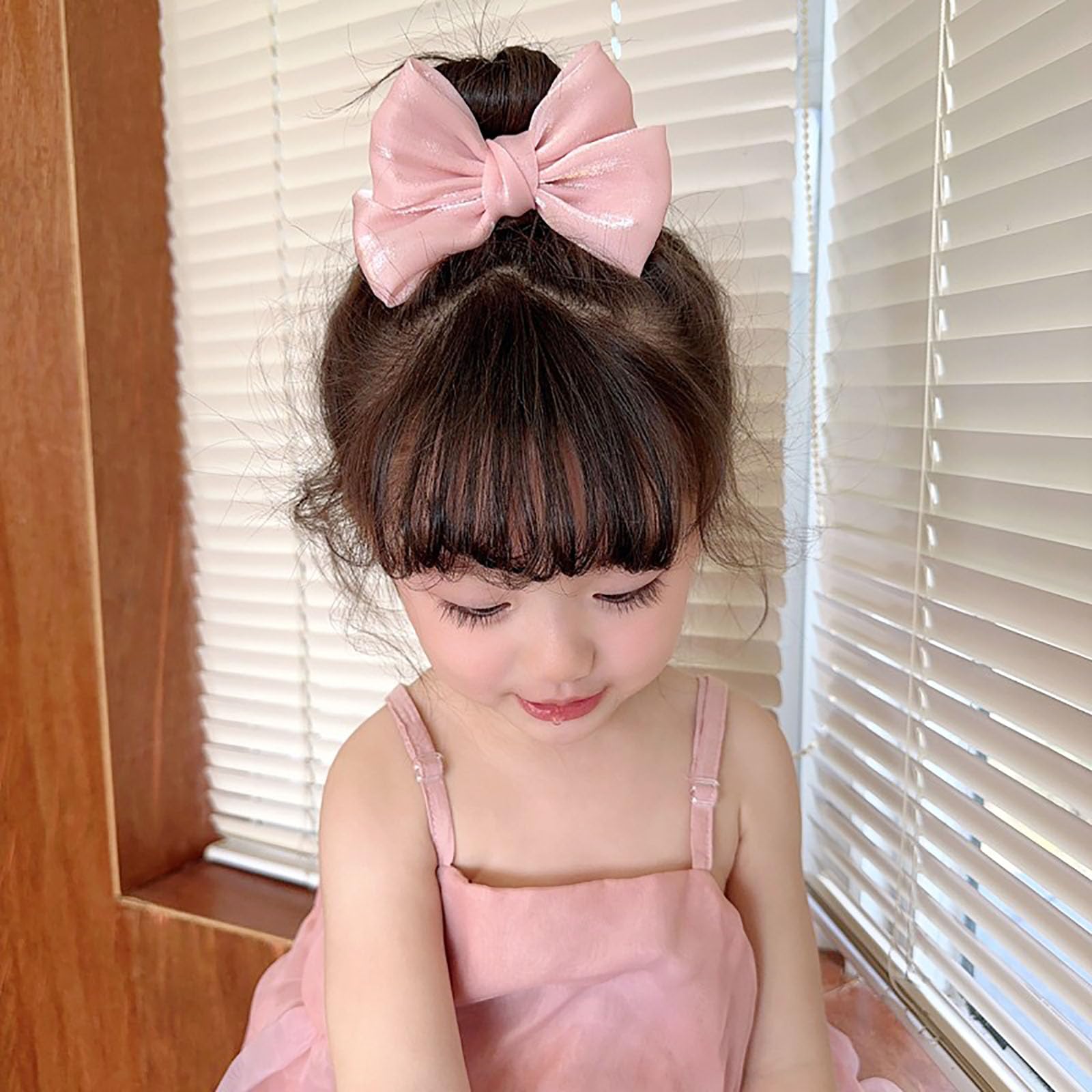 MWRDSM bow clip enhances a chic chignon with a playful pink accent.