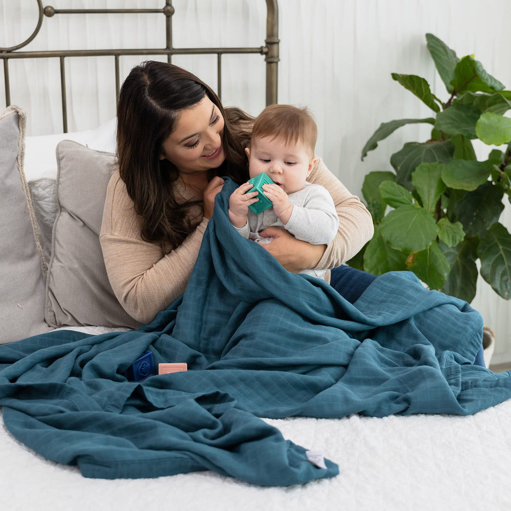 Natemia muslin baby blanket used as stroller cover protecting from sun.
