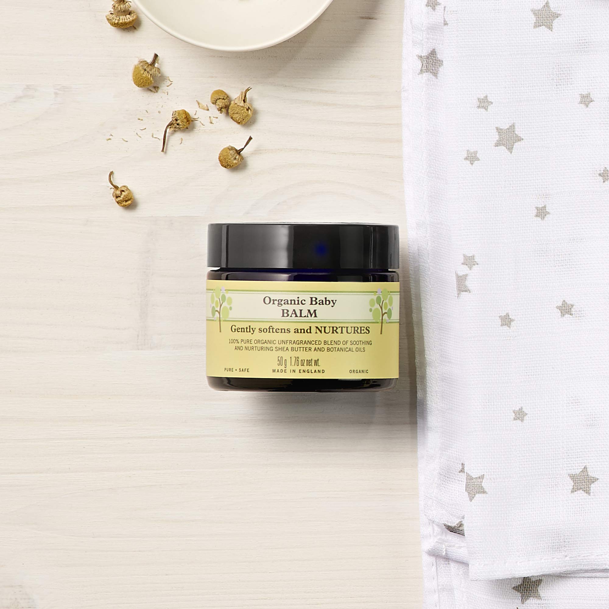 Neal's Yard Remedies Baby Balm application on tiny face demonstrates gentle touch