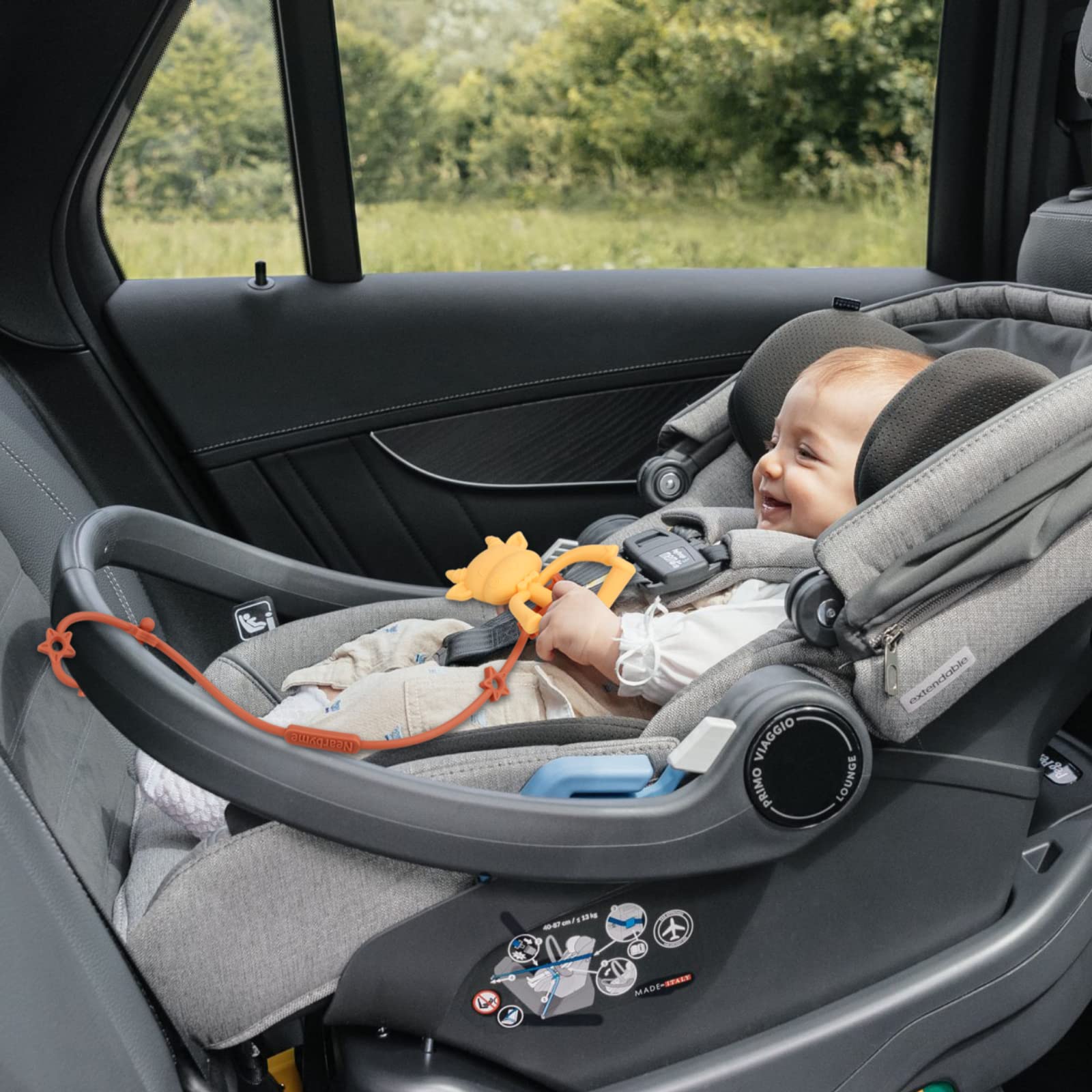 Nearbyme toy straps securing a bottle to a stroller for spill-free feeding.