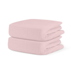 Newton Baby pink 2-pack fitted crib sheet on mattress, breathable organic cotton.