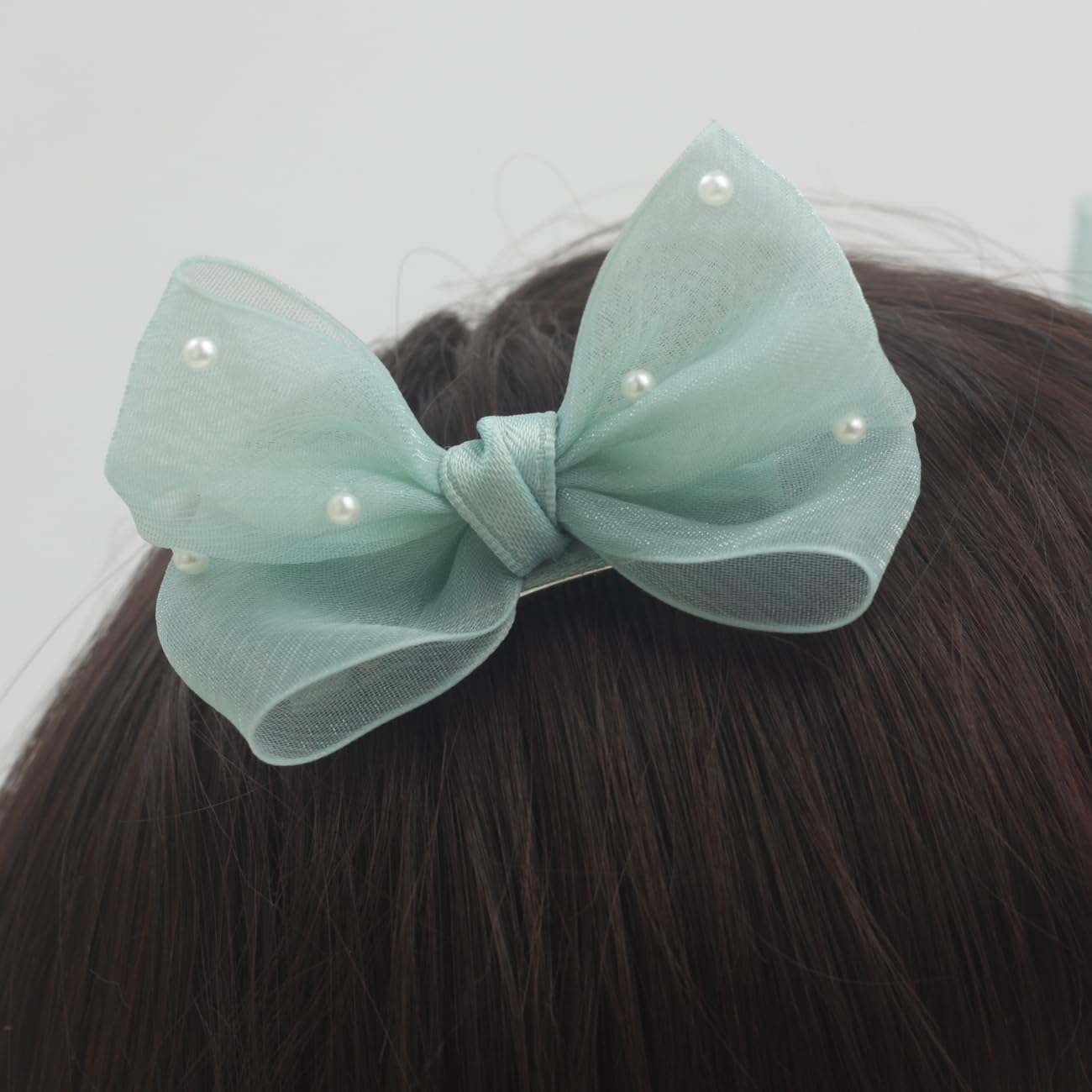 Nihao Baby Pearl Light Green Bow hair clip on dress complements playful outfits