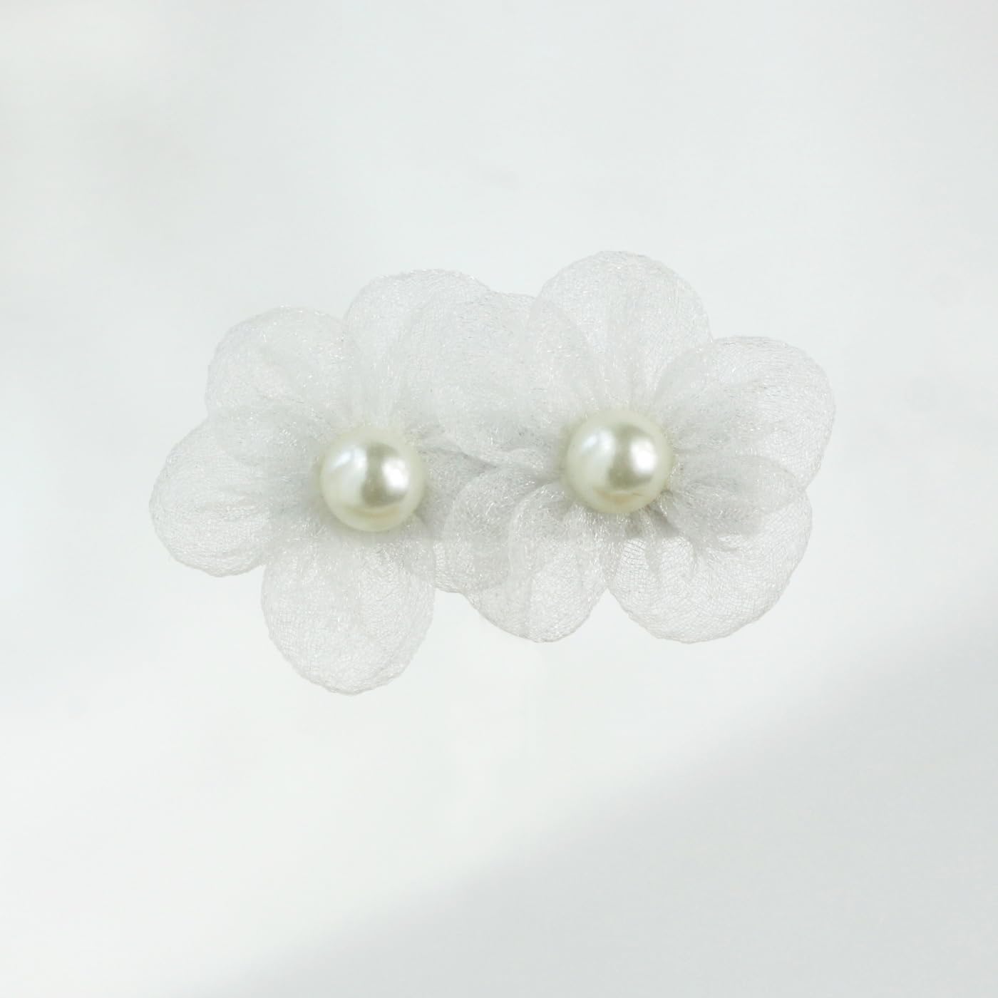 Nihao Baby white flower hair clip in warm light shows soft, photogenic wear