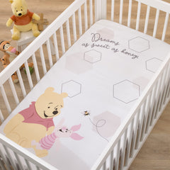 NoJo Disney Pooh Hugs Honeycombs crib sheet on a crib for a photo op