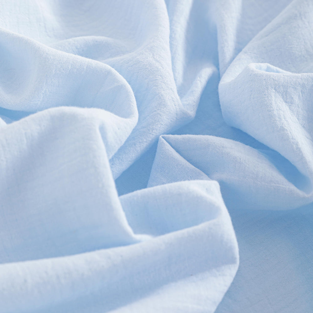 NTBAY mini-crib-sheet-aqua on mattress demonstrates secure 360-degree elastic fit.