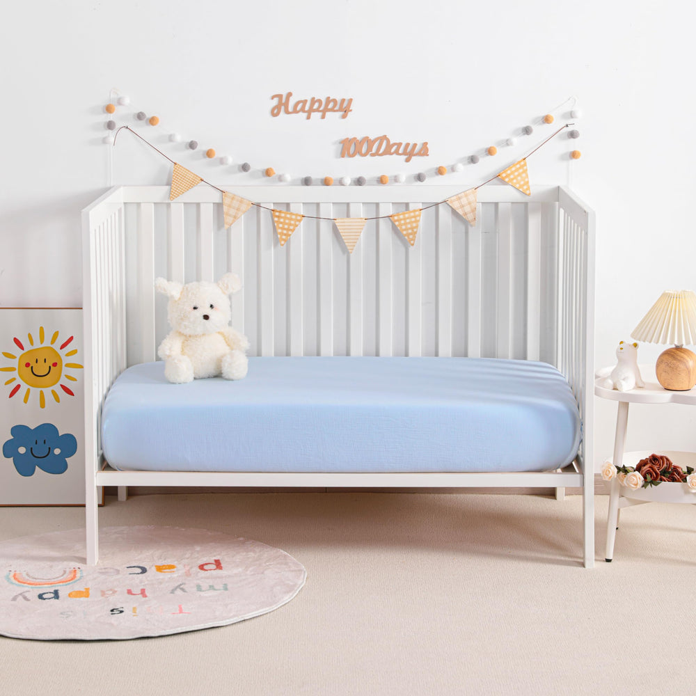 NTBAY mini-crib-sheets-aqua-folded to highlight snug fit and easy handling.