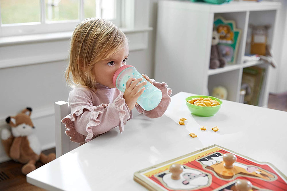 NUK Hide 'n Seek ergonomic cup held by small hands for comfortable sipping.