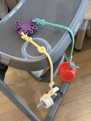 Octopal Baby Tether Straps looped around a high chair for versatility.