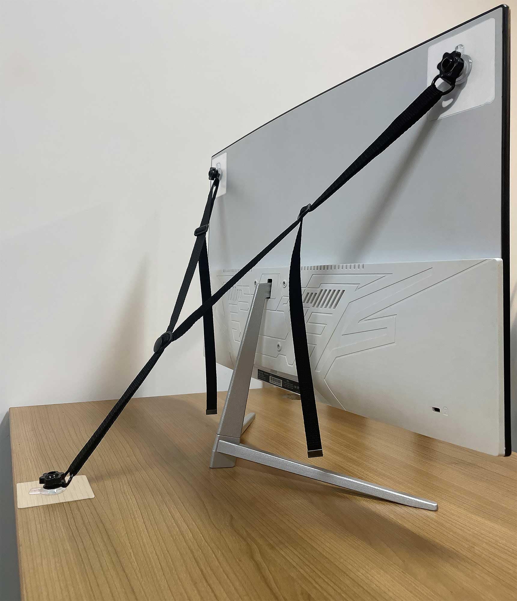 OeckuXIY adjustable TV safety strap mounted to wall for tip-over prevention.