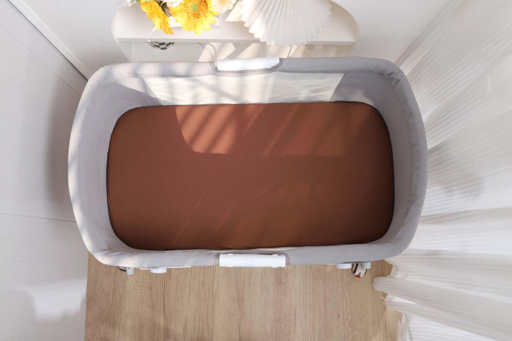 Onacosht universal-fit bassinet sheet—adapts to oval, round, rectangle, and hourglass shapes.