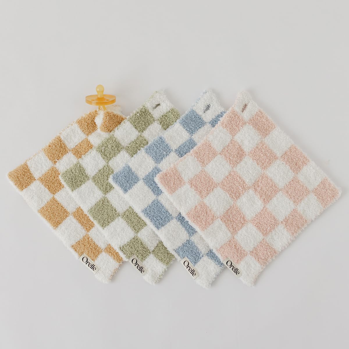 Orelle checkered lovey in nursery scene illustrates gender-neutral decor with functional cuddle buddy