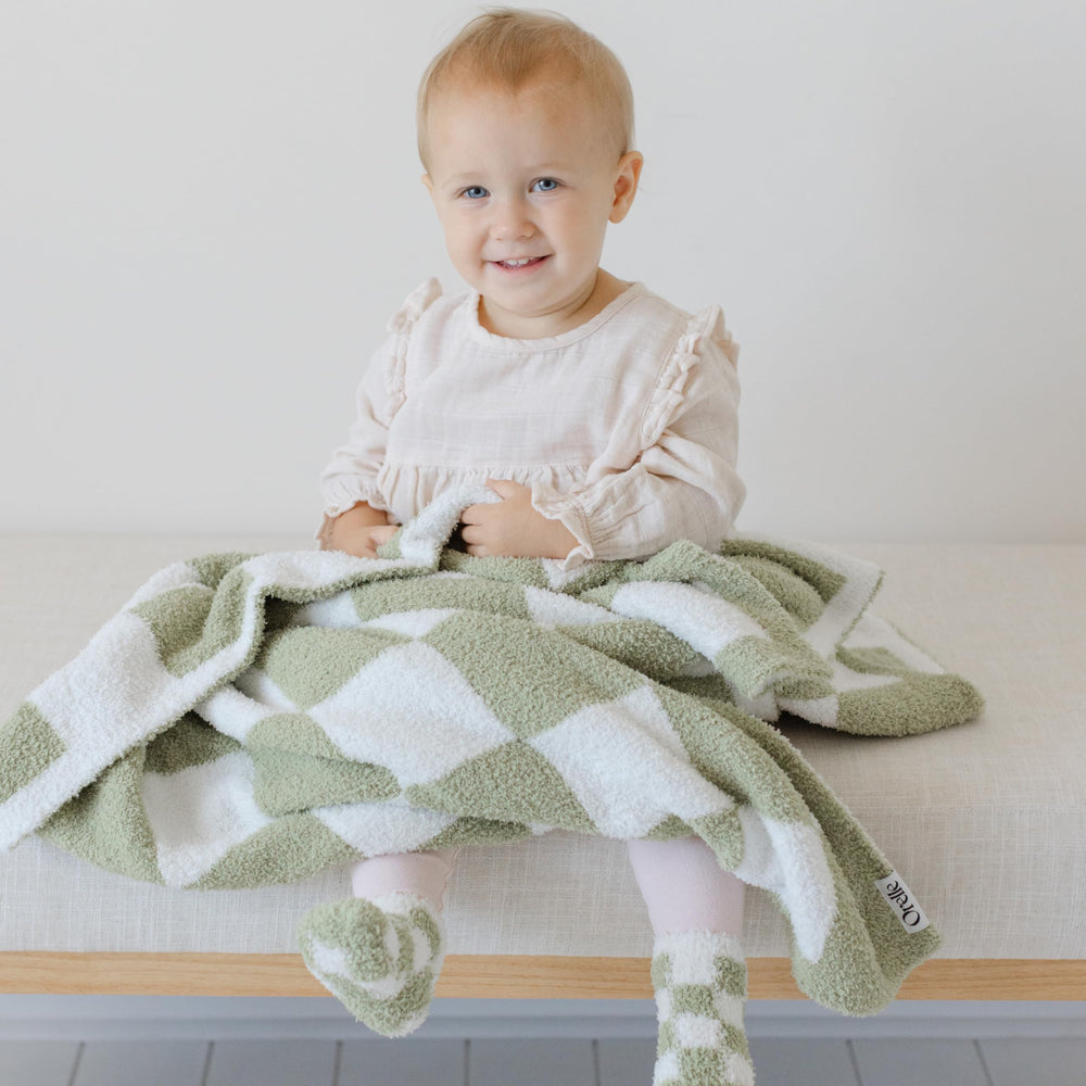 Orelle matching socks with blanket—coordinated look for photos and everyday use.