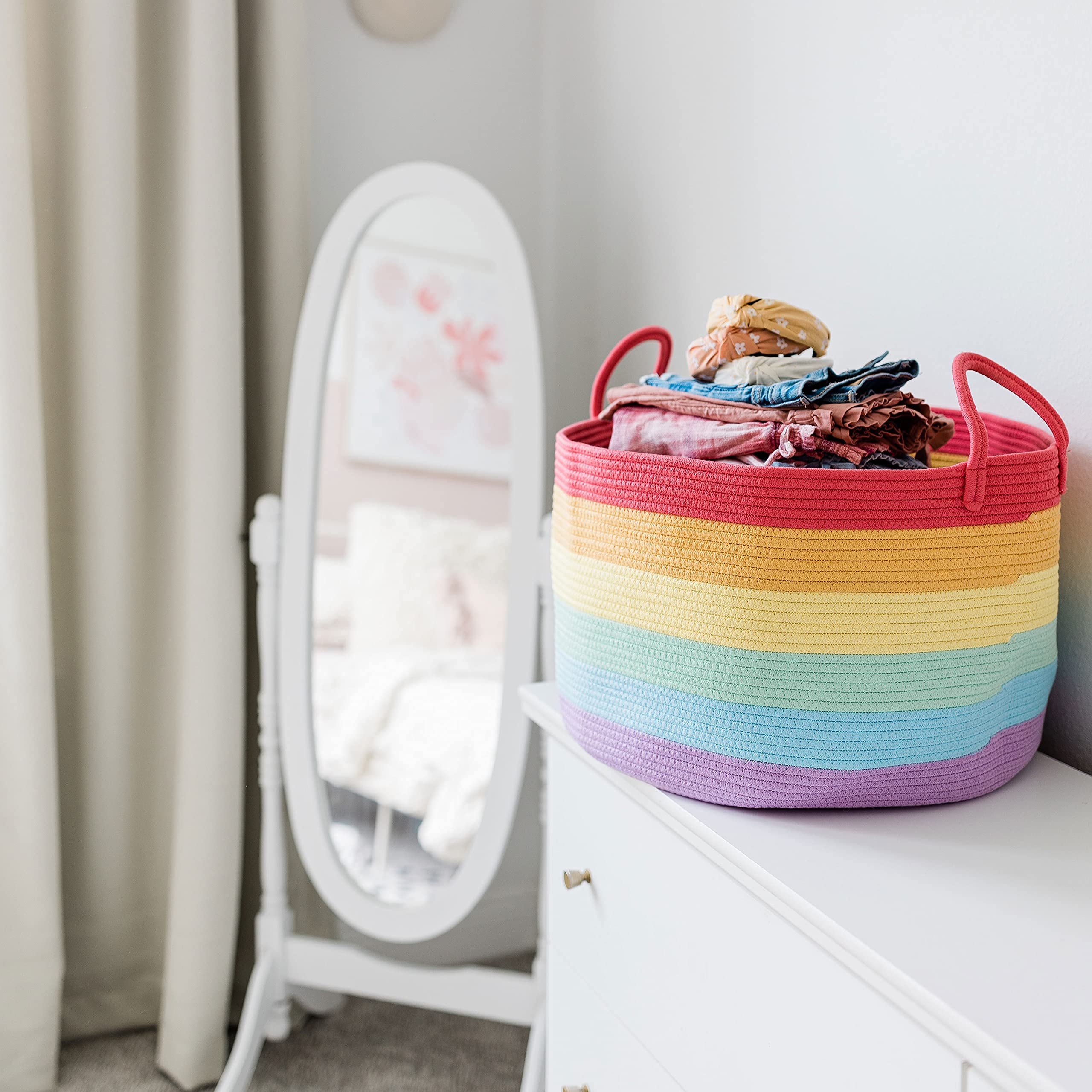 OrganiHaus rainbow basket beside blankets as a cozy blanket storage option