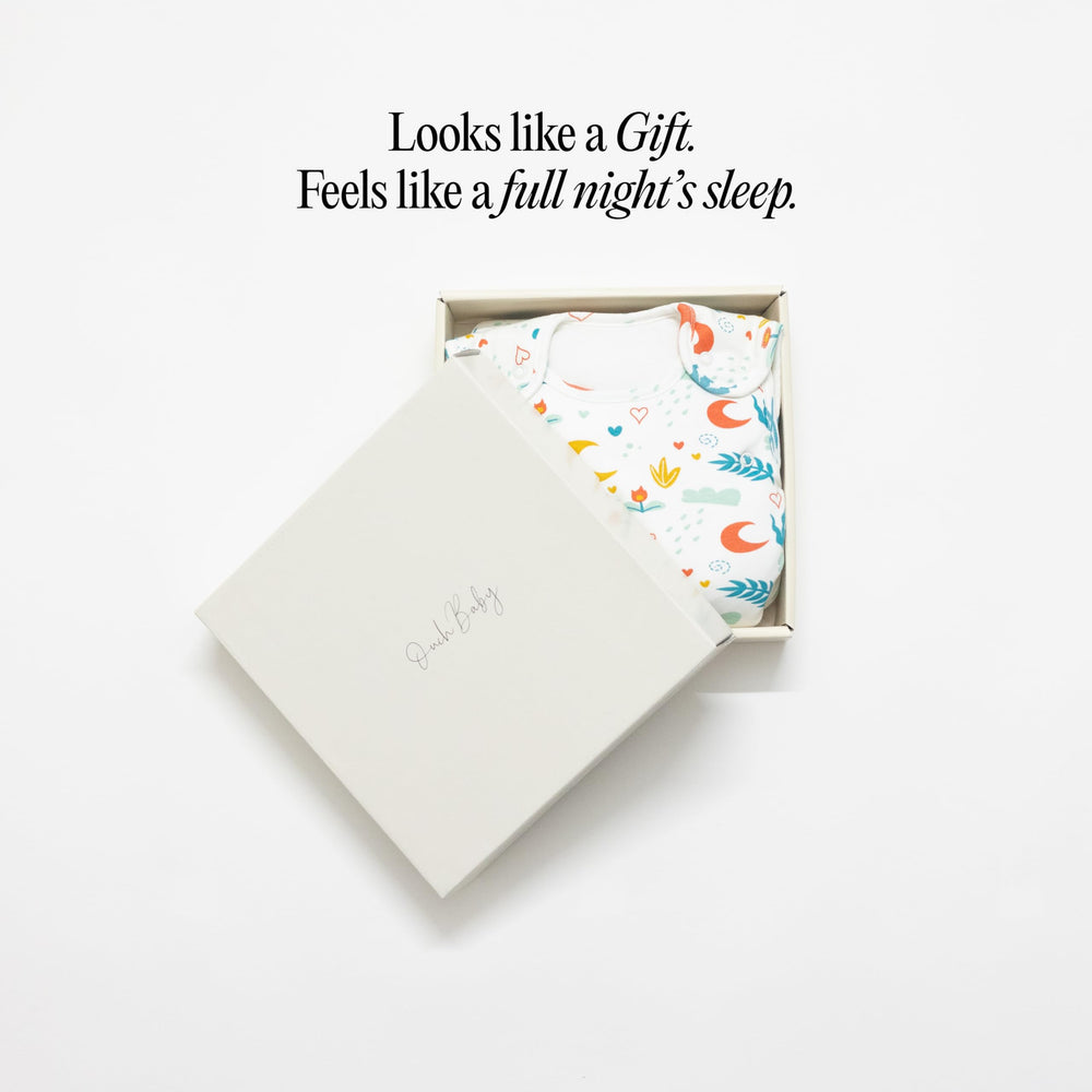 Ouch Baby Sleep Sack on baby in bed illustrates snug, comfortable sleep environment.