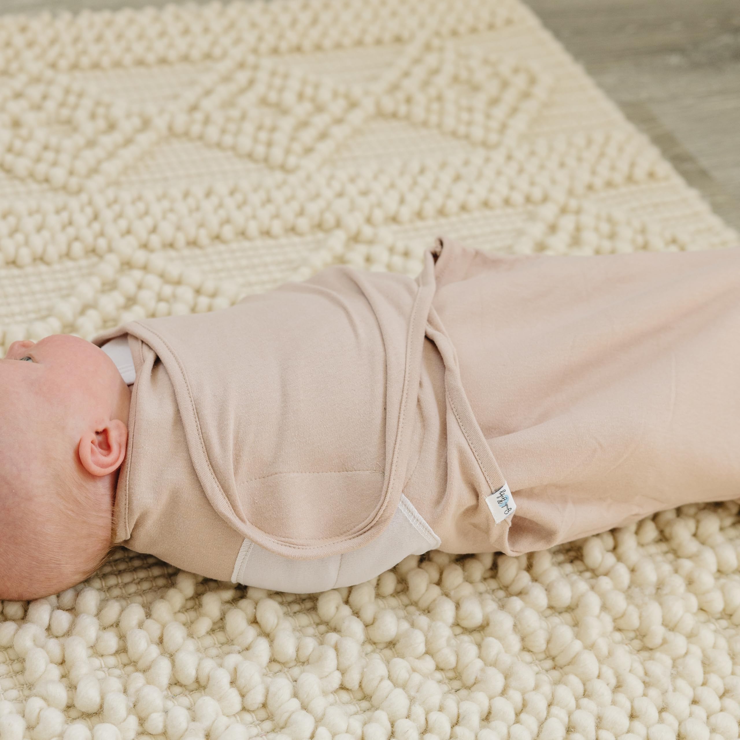 Ouch Baby swaddle with Velcro tabs and adjustable wings for a secure wrap.