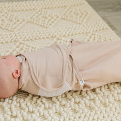 Ouch Baby swaddle with Velcro tabs and adjustable wings for a secure wrap.