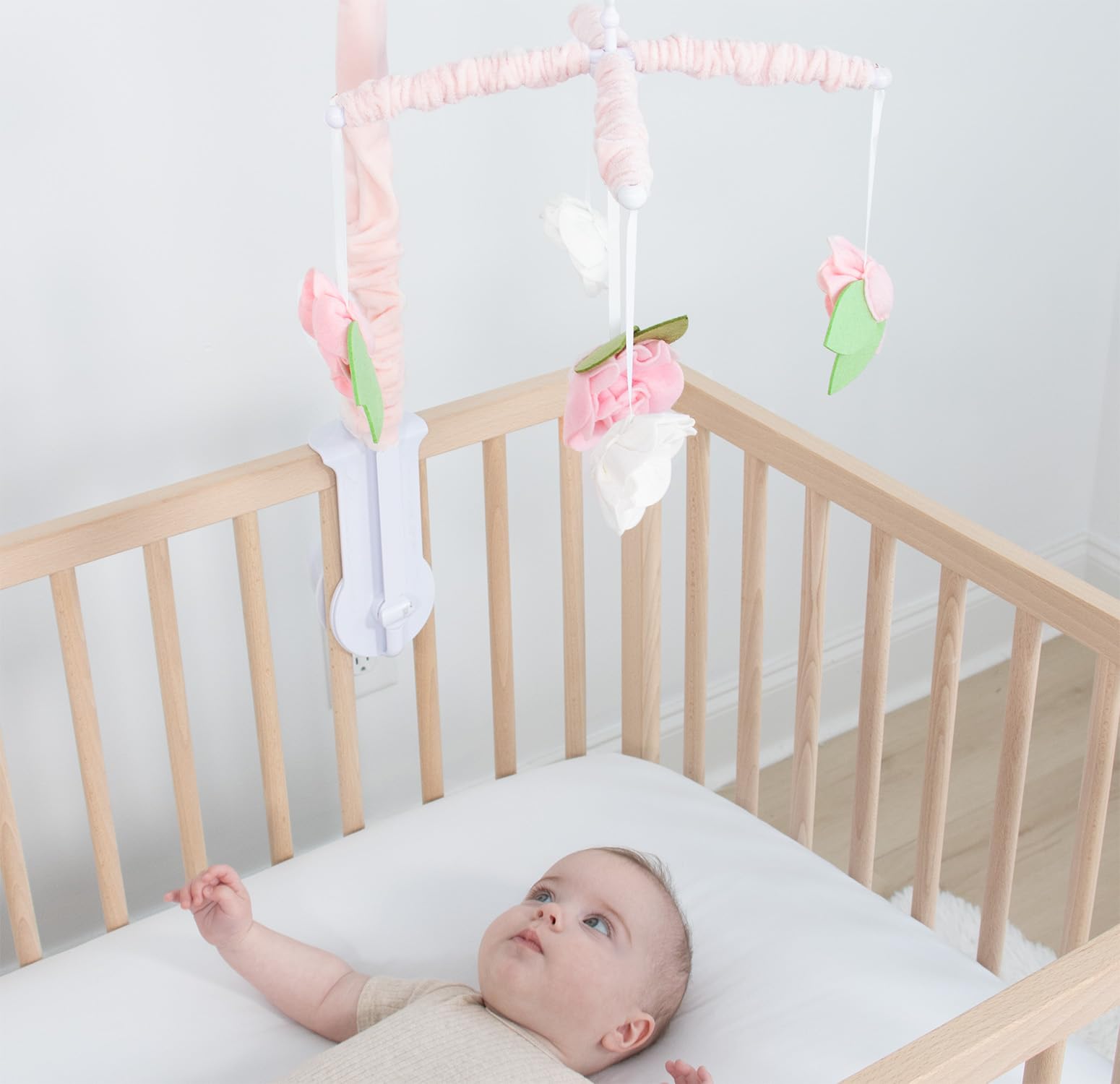 The Peanutshell crib mobile pink flower detail enhances nursery charm.