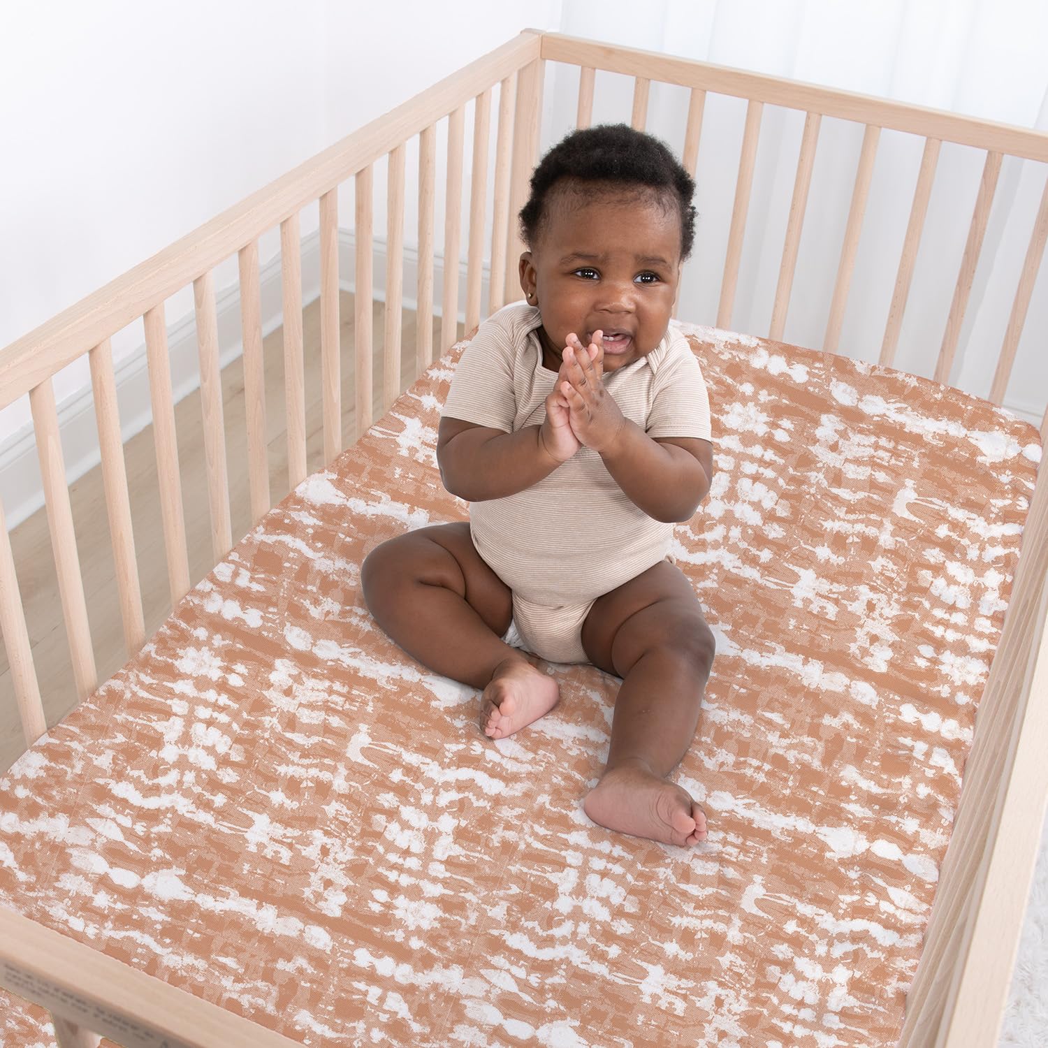 The Peanutshell boho-tie-dye sheets: soft white-sage accents for a versatile nursery.