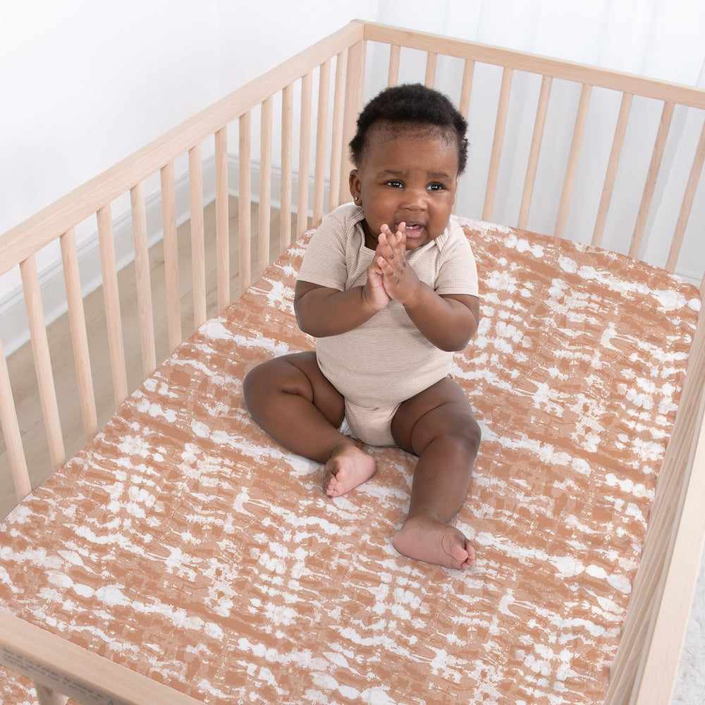 The Peanutshell boho-tie-dye sheets: soft white-sage accents for a versatile nursery.