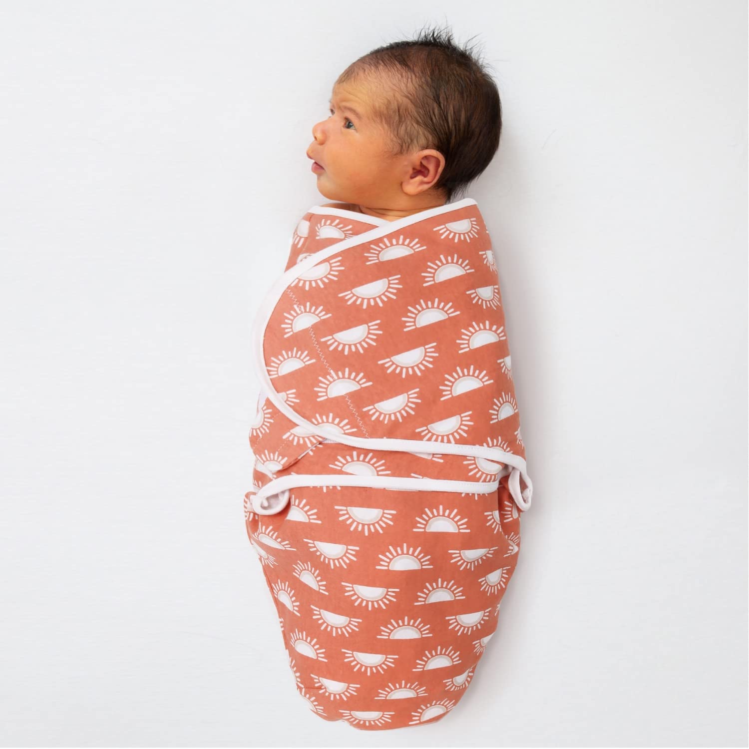 The Peanutshell Desert Safari swaddle on a sleeping baby demonstrates womb-like calm.