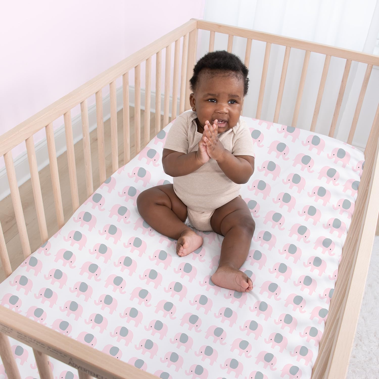 The Peanutshell nursery prints with pink accents create a soothing bedtime vibe.