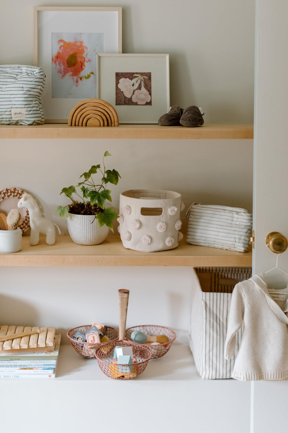 Pehr Pom Pom Basket Mini Blush in nursery for tidy organization.