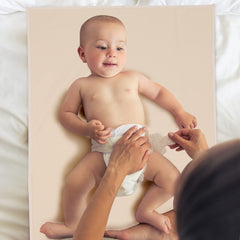 PHOEBUS BABY vegan leather changing mat in apricot folded compactly in a diaper bag.