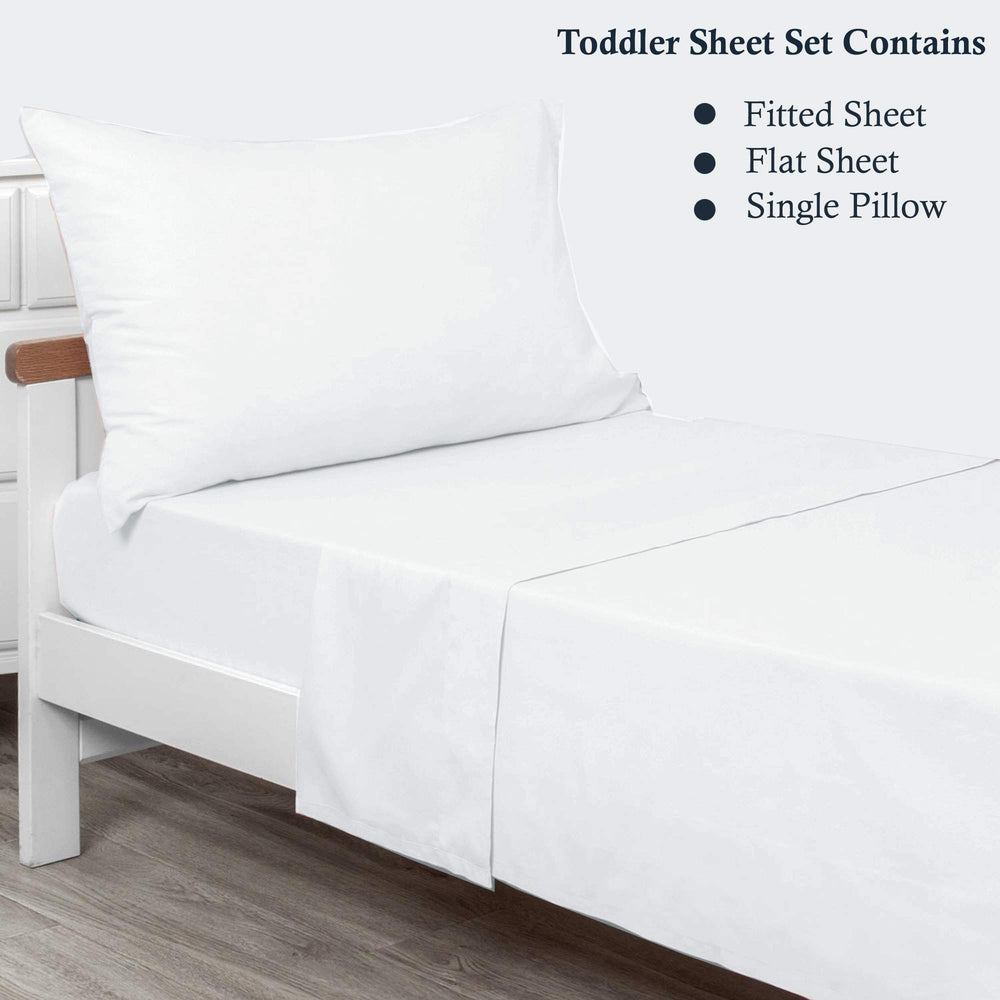 Plain Printed Linen toddler sheet set displayed on bed with neat, secure fit.