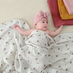 POMISO muslin swaddle blanket earthy colors flat lay for serene nursery aesthetics
