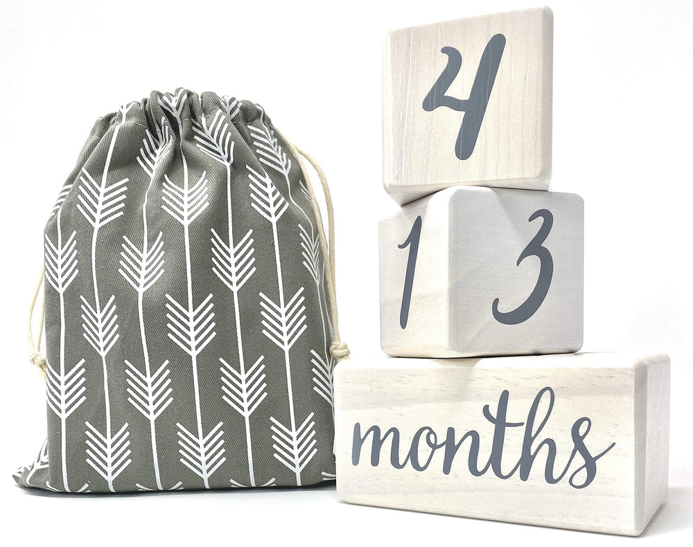 Pondering Pine milestone blocks arranged for a cozy photo setup showing weeks and months.