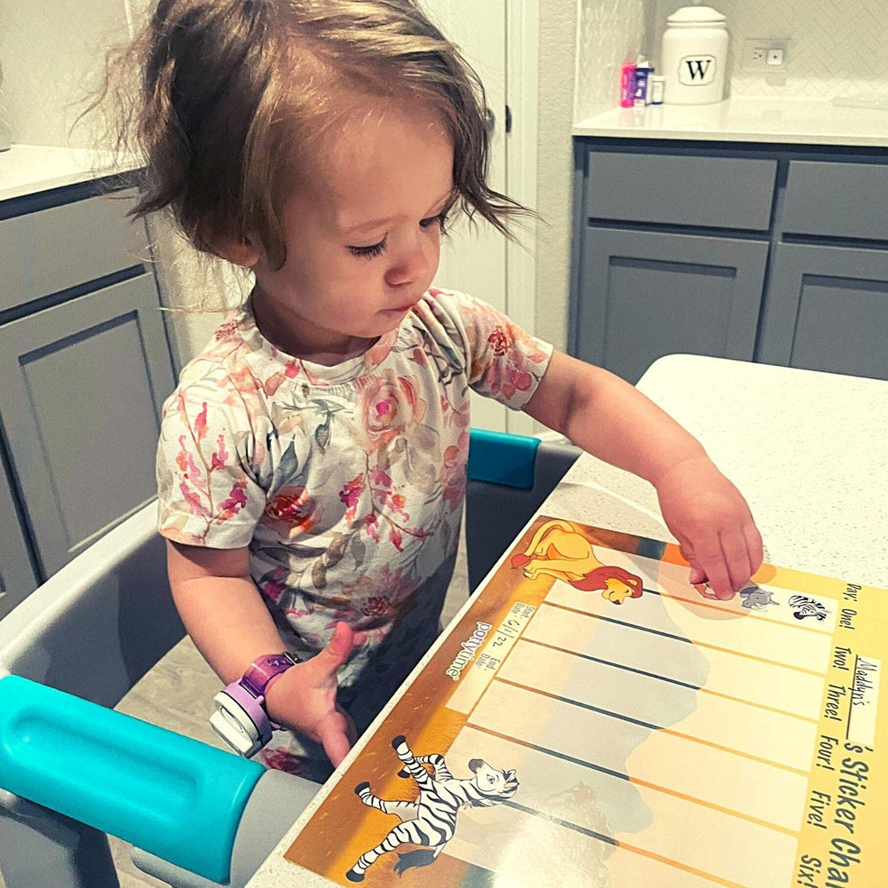 POTTY TIME child placing a sticker on the potty watch chart