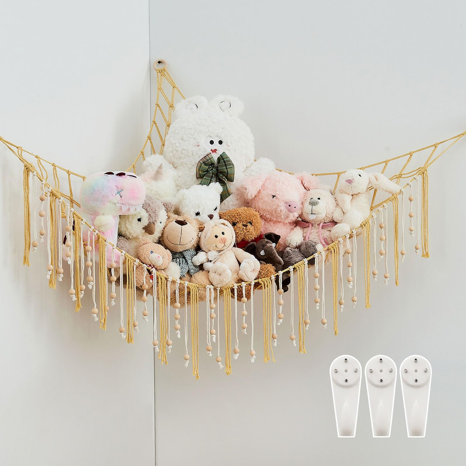 Pretty Jolly stuffed animal storage hammock with yellow tassels keeps plush toys organized in a kid's room.