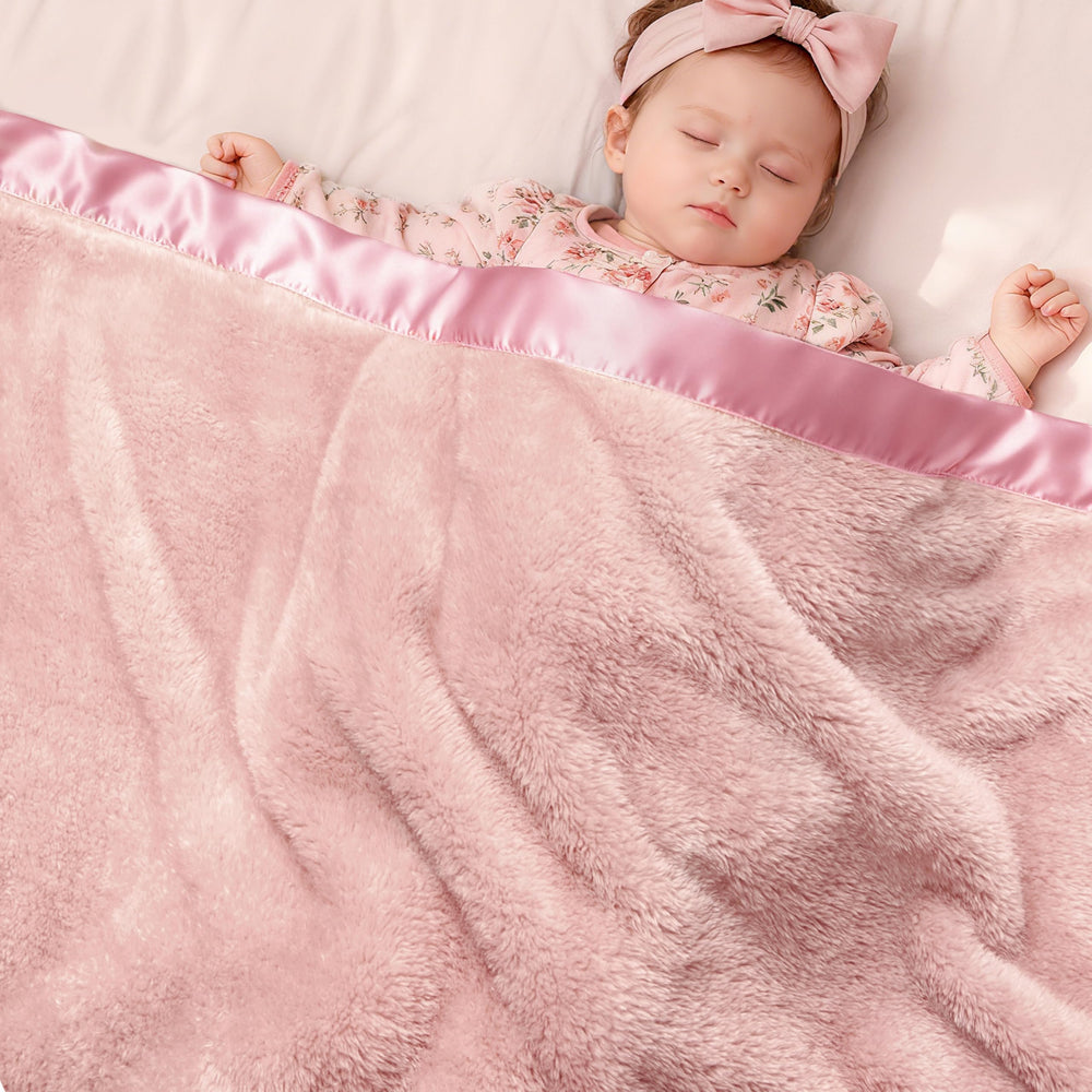 Pro Goleem pink satin-trim fleece baby blanket adds elegant warmth for cuddles.