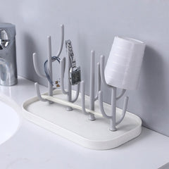 Pujito drying rack holds teats, cups, and pump parts for air-drying.