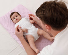 QUENESS BABY changing pad cover demonstrates fit on standard pads for secure use.
