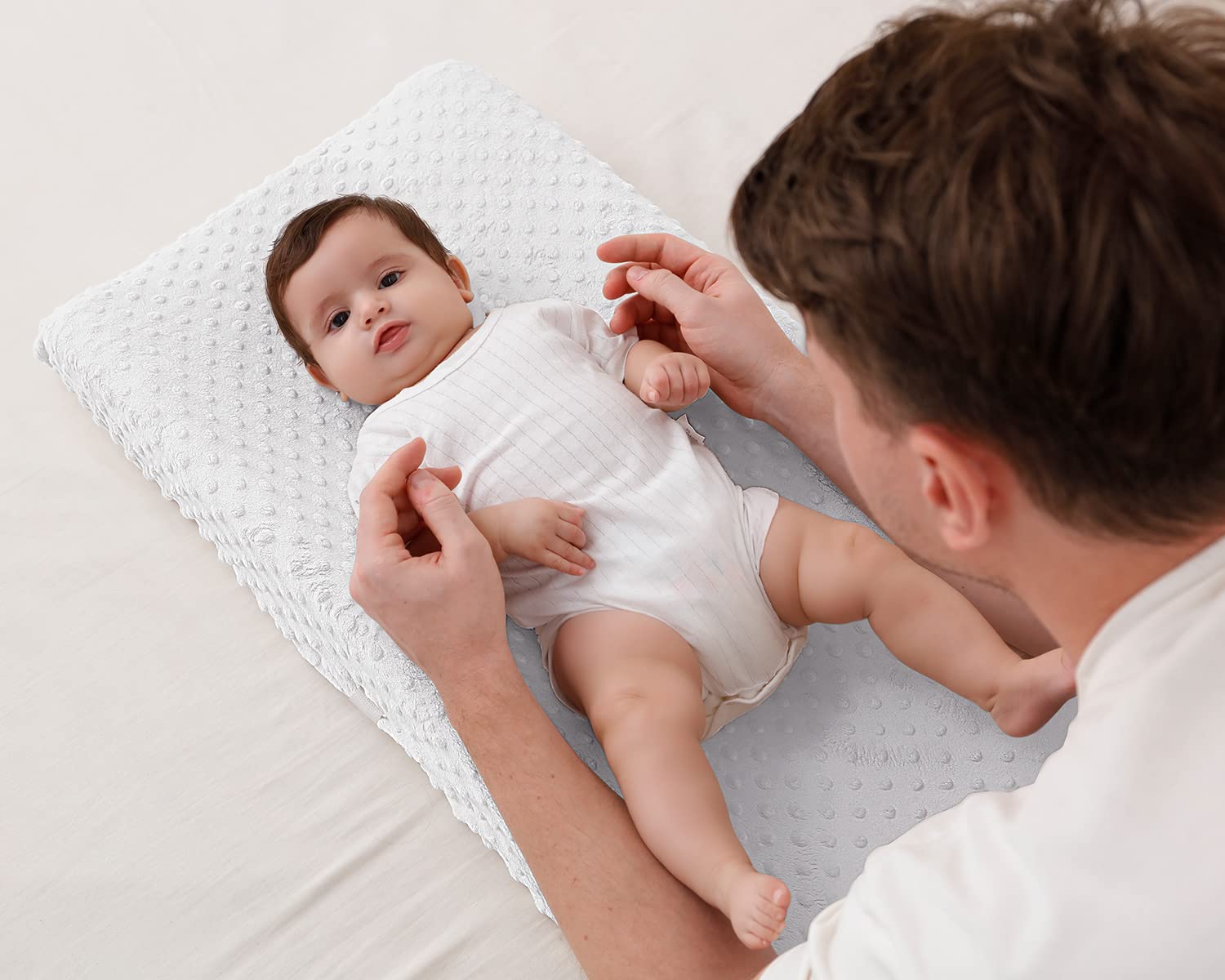 QUENESS BABY Cloud Dancer on changing pad demonstrates secure fit.