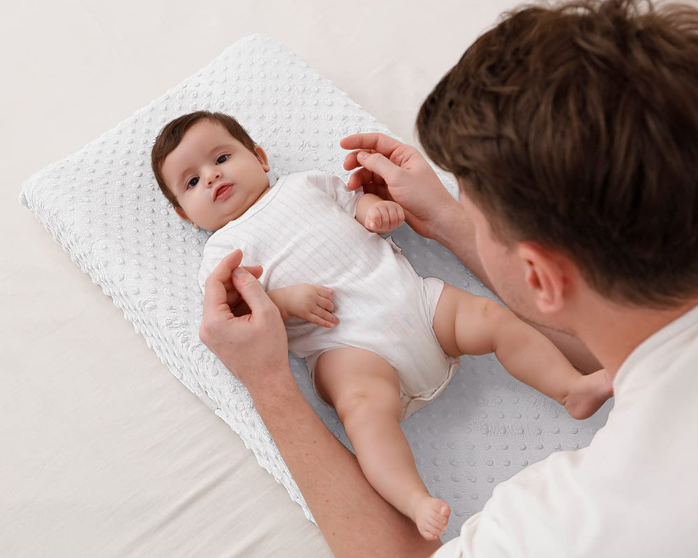 QUENESS BABY Cloud Dancer on changing pad demonstrates secure fit.
